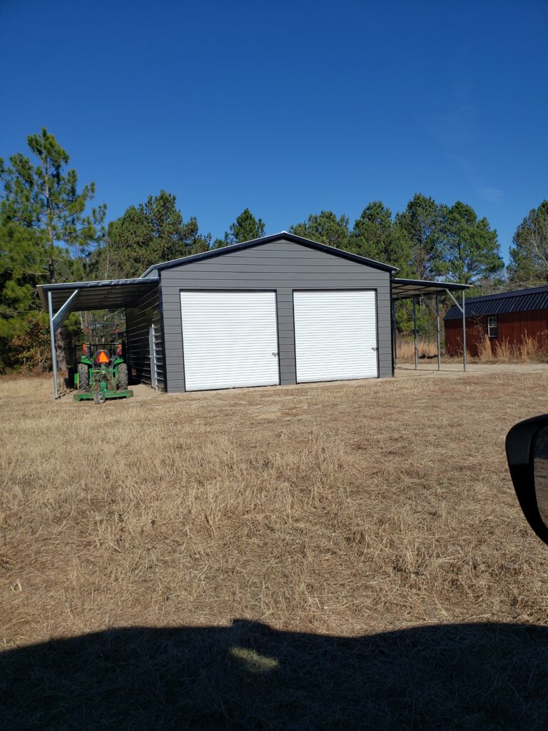 A tractor parked in front of two garage doors.