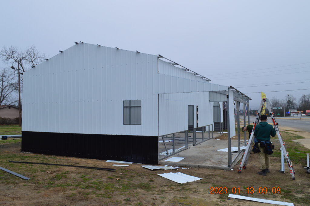 A white building with black trim and some metal bars