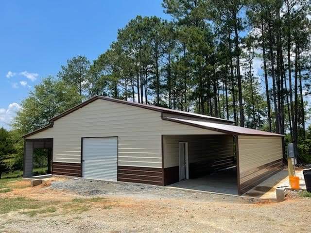 A large garage with two doors and a carport.