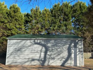A white garage with trees in the background