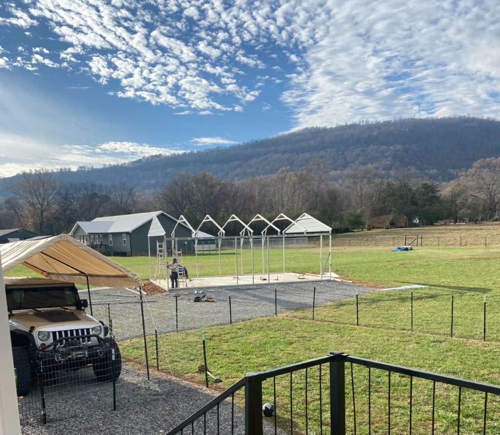 A view of an outdoor area with tents and a fence.