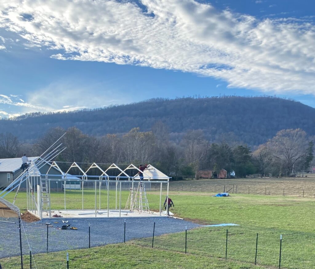 A field with a fence and some buildings