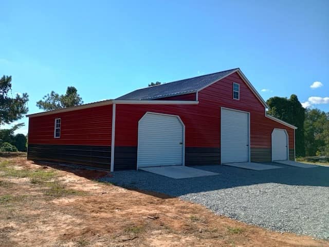 Red barn with two white garage doors.