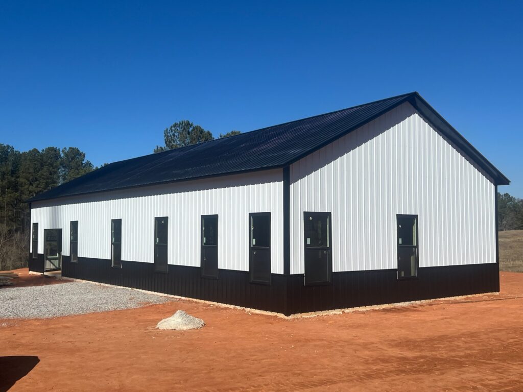 Black and white metal building with six garage doors.